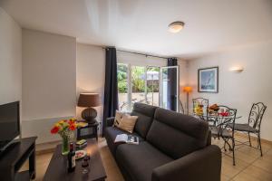 un soggiorno con un divano e un tavolo di Lagrange Vacances - Résidence Jardin Mauresque ad Arcachon