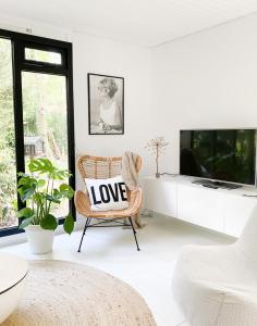 a living room with a love pillow on a chair at Dromen op 1 - Stijlvol boshuis op de Veluwe met veranda en grote omheinde tuin! in Nunspeet