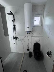 a bathroom with a black toilet and a window at Apartman Andrija in Igalo