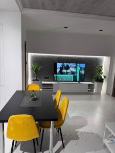 a dining room with a table and yellow chairs at Apartman Andrija in Igalo