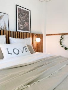a bedroom with a bed with a love sign on it at Dromen op 1 - Stijlvol boshuis op de Veluwe met veranda en grote omheinde tuin! in Nunspeet +33 photos
