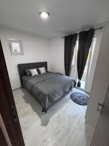 a bedroom with a bed and a large window at Apartman Andrija in Igalo