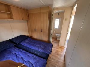 a bedroom with a blue bed and a bathroom at ZP 655 - Camping de Zandput in Vrouwenpolder