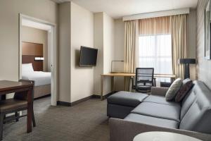 a hotel room with a couch and a bed at Residence Inn by Marriott Ottawa Airport in Ottawa