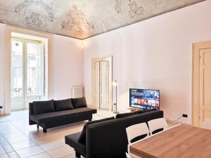 ein Wohnzimmer mit Sofa und Fernseher in der Unterkunft Al Donà in Bari