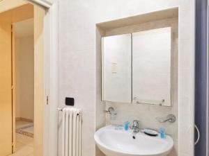 ein weißes Badezimmer mit Waschbecken und Spiegel in der Unterkunft Al Donà in Bari