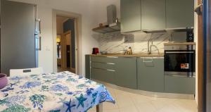 a kitchen with green cabinets and a table with a tablecloth at La Casa al Mare in Rapallo