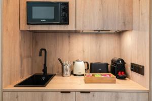 Una encimera de cocina con fregadero y microondas. en Dobo Madrid Betanzos, en Madrid