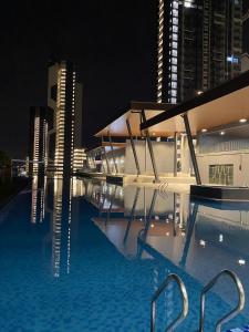 a swimming pool at night with tall buildings at Mellgyp Homestay Bangi Kajang in Kajang