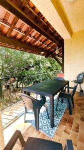 a green table and chairs on a patio at Chez le Grand in Maraussan