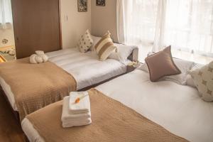 two beds in a room with towels and pillows at Direct to Shinjuku Two bedrooms Higashi-Nakano Station Free luggage storage in Wada
