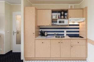 a small kitchen with a sink and a microwave at Seestern - Charmante 2-Zimmer-Wohnung mit Balkon in Zingst