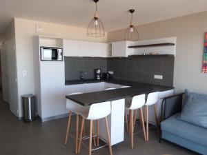 a kitchen with a black counter top and white cabinets at Appartement en bord de mer, 2 chambres, piscine, parking, animaux admis - FR-1-194-231 in La Tranche-sur-Mer +15 photos