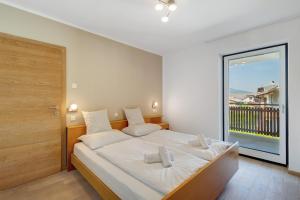 una camera da letto con un letto grande con una grande finestra di Apt Hofer Barbara a Villabassa