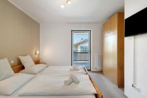 una camera da letto con un grande letto bianco e una televisione di Apt Hofer Barbara a Villabassa