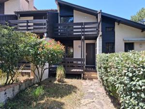 a house with a porch with a bench in front of it at Villa Patio Duplex Calme, Proche Plage et Commerces, Idéale pour 4 Pers. - FR-1-239-237 in Seignosse