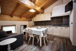 eine Küche und ein Esszimmer mit einem weißen Tisch und Stühlen in der Unterkunft Da Cinto in Paluzza