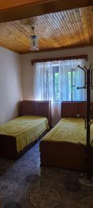 zwei Betten in einem Zimmer mit Fenster in der Unterkunft House in Leskovik in Leskovik