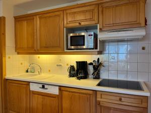 a kitchen with a sink and a microwave at Appartement 52m², Terrasse, Parking, Cœur de Samoëns, Ski & Commerces Proches - FR-1-624-19 in Samoëns +11 photos