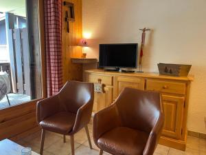 a living room with two chairs and a television at Appartement 52m², Terrasse, Parking, Cœur de Samoëns, Ski & Commerces Proches - FR-1-624-19 in Samoëns
