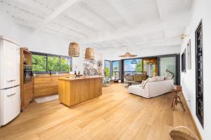 a kitchen and living room with wood floors and windows at Lodge Nature in Saint-Leu