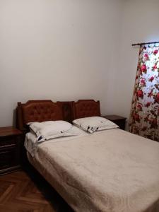 a bed with two white pillows and a curtain at Blažo in Neviđane