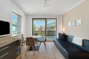un soggiorno con un divano e un tavolo con sedie di Apt Hofer Barbara a Villabassa