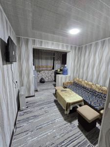 a living room with a couch and a table at Firdausi Apartment in Khujand