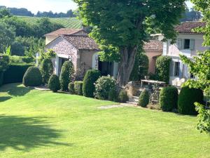 a house with a green lawn in front of it at Clos de la Besnardière in Tabanac