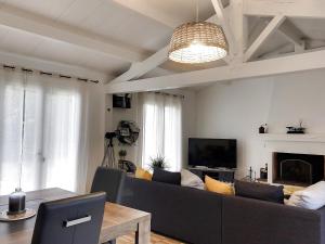 a living room with a couch and a tv at Maison 3* proche plage, forêt et pistes cyclables avec jardin, barbecue et WIFI - FR-1-652-12 in Saint-Jean-de-Monts