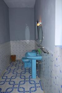 bagno con servizi igienici blu e lavandino di Hotel Nautile a Sainte Marie