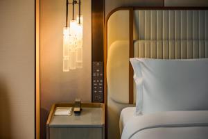 a hotel room with a bed and a nightstand with a bed sidx sidx sidx at InterContinental Taichung by IHG in Taichung
