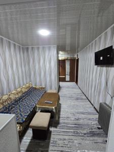 a room with a bed and a tv in it at Firdausi Apartment in Khujand