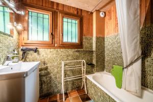 a bathroom with a bath tub and a sink at Chalet Chez Juju in Abondance +29 photos