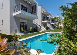 a swimming pool in front of a house at Diamond Apartment 1 Ofrinio Beach in Ofrínion