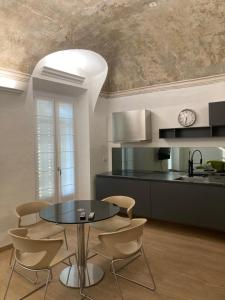 a dining room with a table and chairs and a kitchen at Casa sulla Piazzetta in Saluzzo