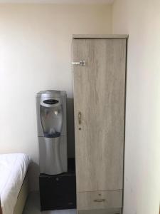 Una habitación con una cafetera al lado de una puerta de madera. en غرفة نوم بالشارقة, en Sabkhah