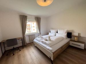a bedroom with a bed and a desk and a window at Apartment Annabell - Alpstay in Naturno