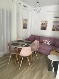 a living room with a purple couch and a table and chairs at Diamond Apartment 1 Ofrinio Beach in Ofrínion
