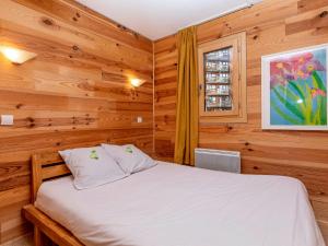Un dormitorio con una cama con paredes de madera y una ventana en Appartement 3 pièces pour 6 pers. avec balcon et wifi, proche pistes et commerces à Avoriaz - FR-1-314-152, en Morzine