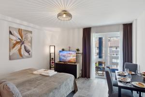 a bedroom with a bed and a table and a tv at Schönes City Apartment Wuppertal in Wuppertal