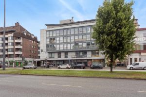 a large building with cars parked in front of it at Schönes City Apartment Wuppertal in Wuppertal
