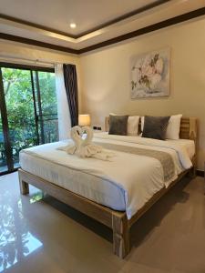 a bedroom with a large bed with a towel on it at Bang Po Hut in Ban Bang Po