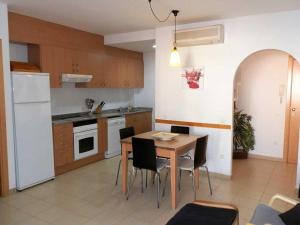 a kitchen with a table and chairs and a white refrigerator at Vacaciones ideales: apto con piscina, cerca del mar, wifi, aire opcional, admite mascotas, playa perros - ES-184-11 in Riumar