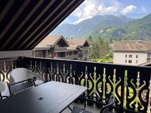 a balcony with a table and chairs and mountains at Appartement T2 au centre de Samoëns avec parking, animaux acceptés - FR-1-624-43 in Samoëns