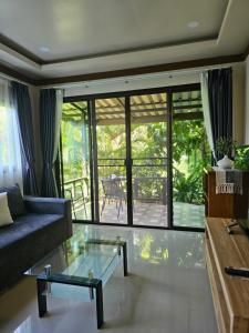 a living room with a couch and a glass table at Bang Po Hut in Ban Bang Po
