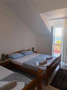 a bedroom with two beds and a large window at Apartman Igalo Stana in Igalo