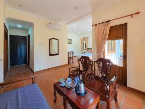 a living room with wooden chairs and a table at Sai Gon Can Gio Resort in Cần Giờ