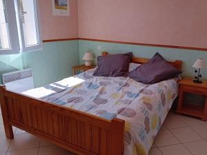 a bedroom with a large bed with purple pillows at **Maison récente, proche plage, commerces et plan d'eau - L'Aiguillon-sur-Mer** - FR-1-194-275 in LʼAiguillon-sur-Mer