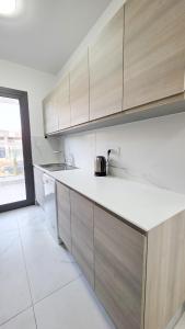 a kitchen with wooden cabinets and a tea kettle on the counter at Poolside Lux Apartment in Larnaka +6 photos